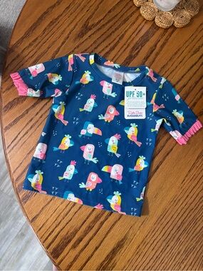 Ruffle Butts Navy Swim Shirt with Colorful Tropical Parrots and Pink Ruffle Trim